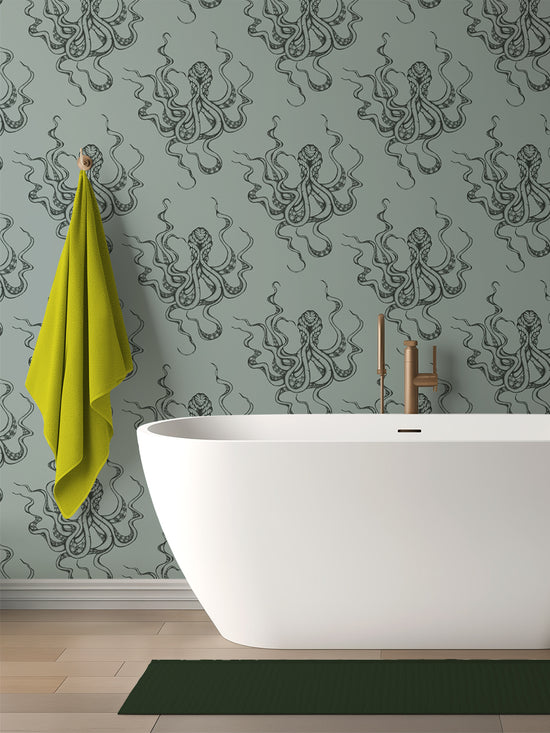 Kraken Steel wallpaper in bathroom setting with freestanding bath; moody green-grey tones with shimmering octopus design.