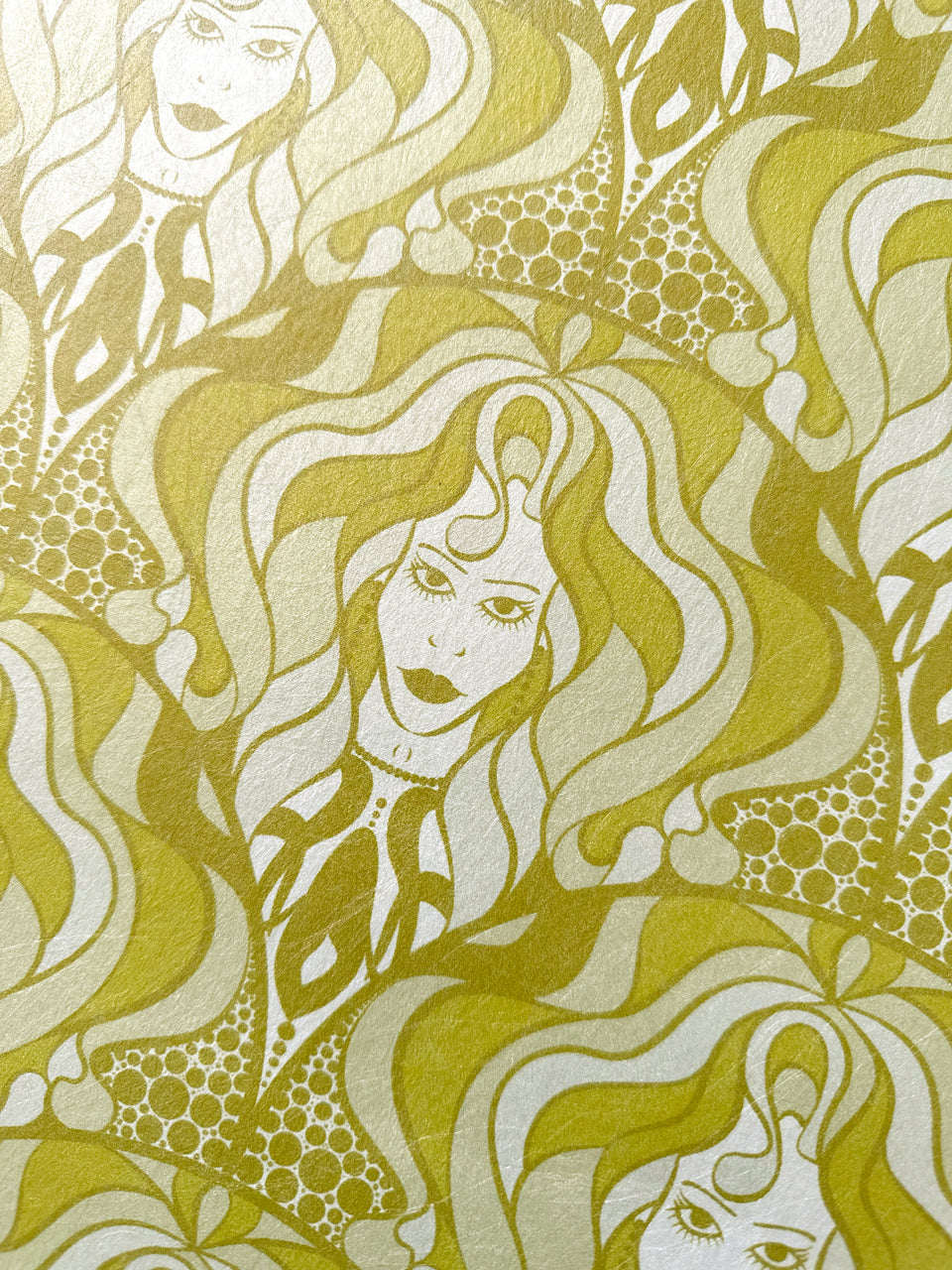 Hand-illustrated champagne and gold parchment wallpaper with retro feminine faces and shimmer.