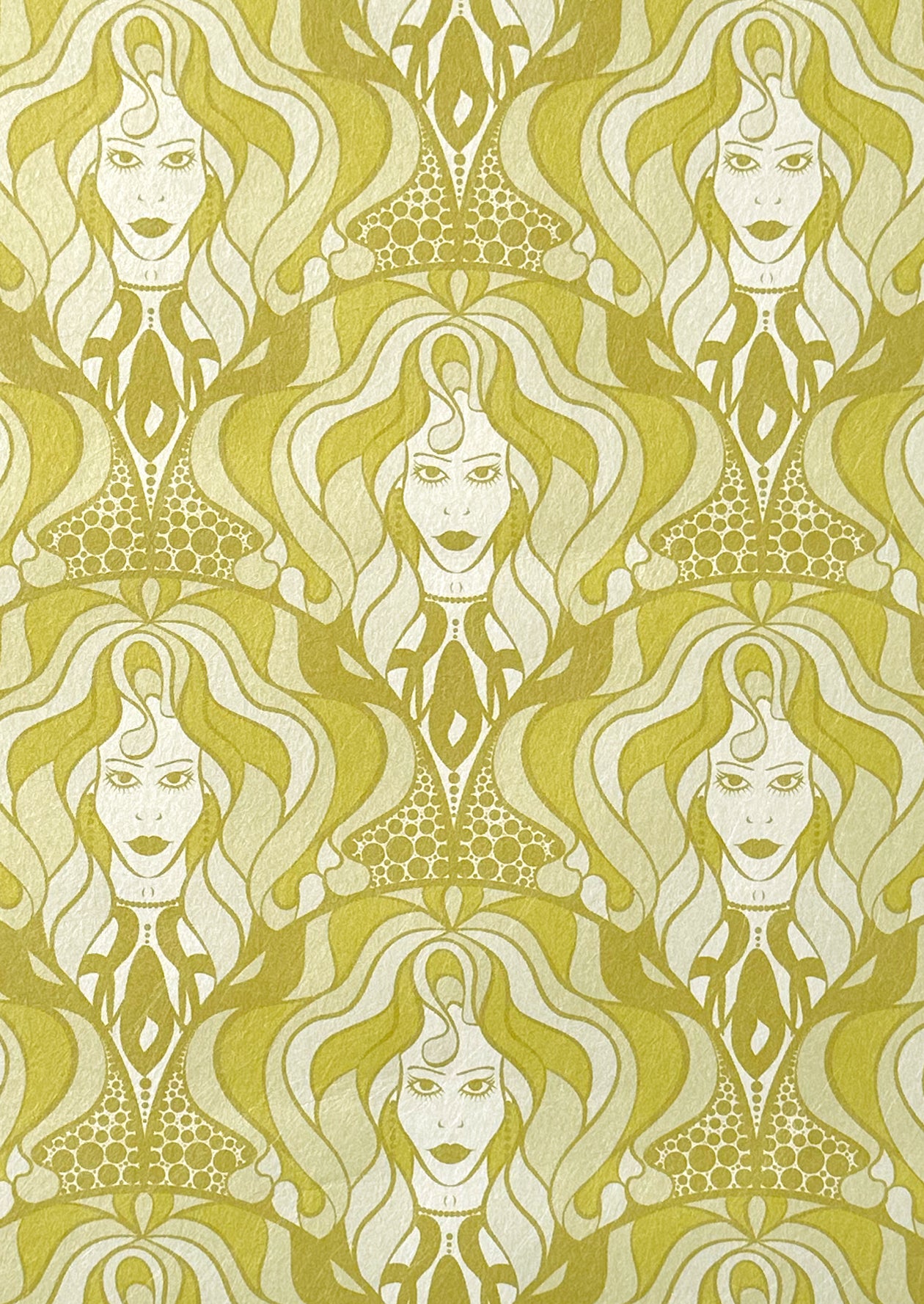Sample sheet of Lady Marmalade wallpaper in brass shimmering tones and biba-style face motifs.