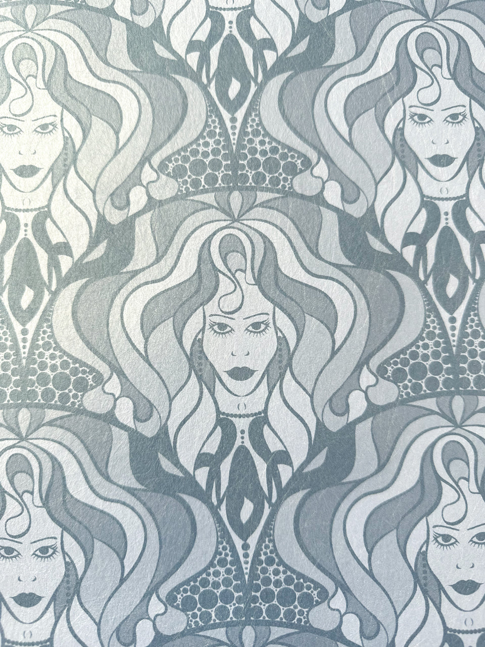 Biba-inspired 1970s wallpaper design in shimmering grey with bold feminine detailing.