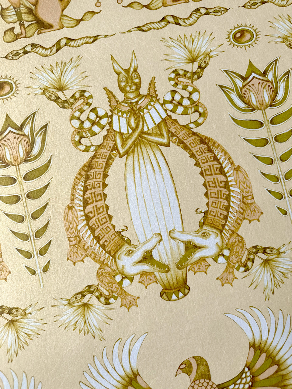 Detail of crocodile print from the Egyptian-inspired Nefertiti Cream wallpaper with luxe gold tones.
