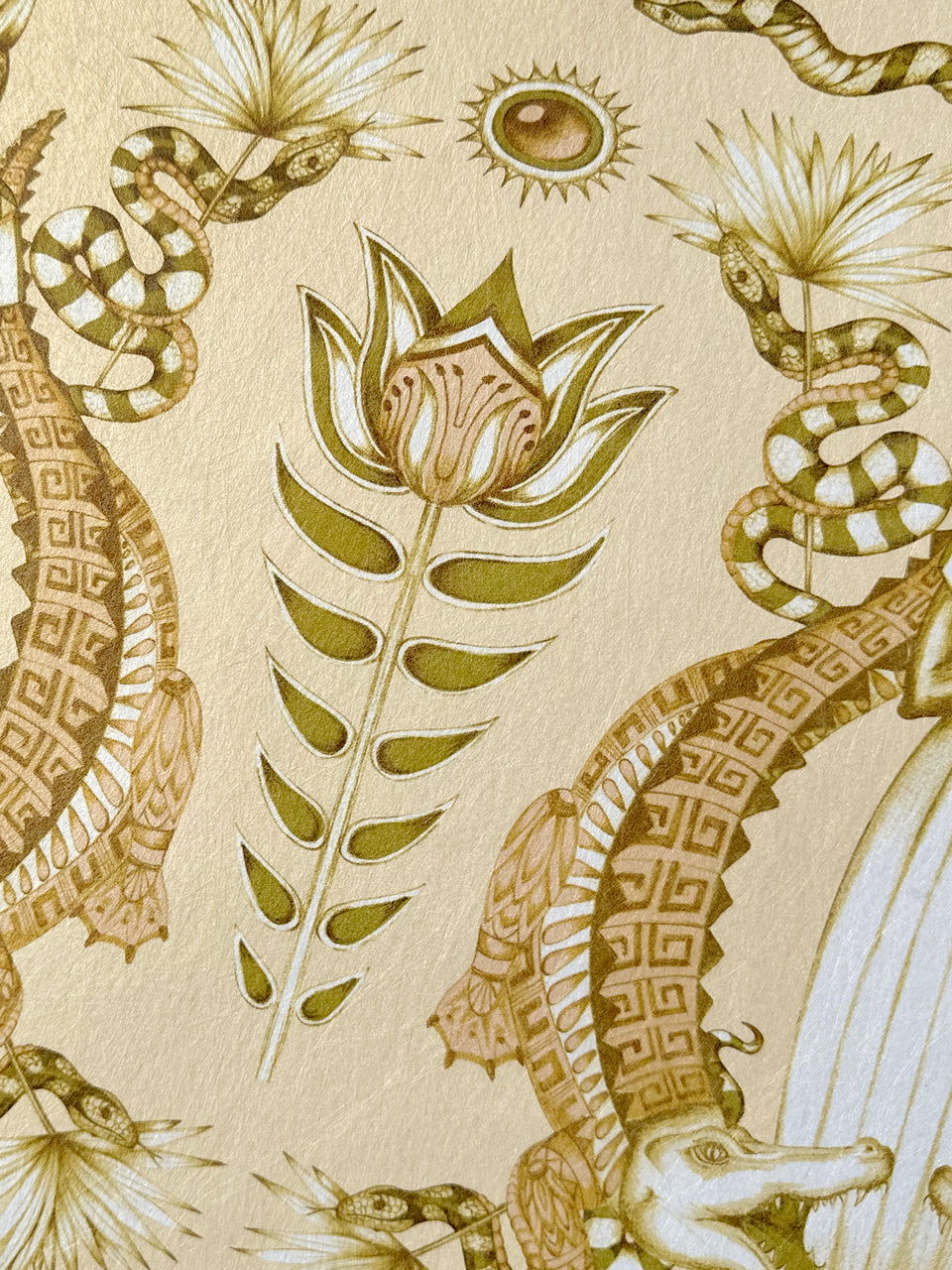 Close-up of floral detailing on the opulent Nefertiti Cream wallpaper with gold parchment finish.