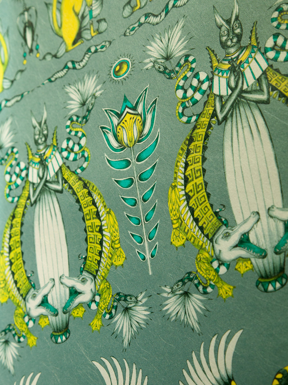 Luxe wallpaper finish with jewel-toned lotus flowers and intertwined snakes in emerald and parchment tones.