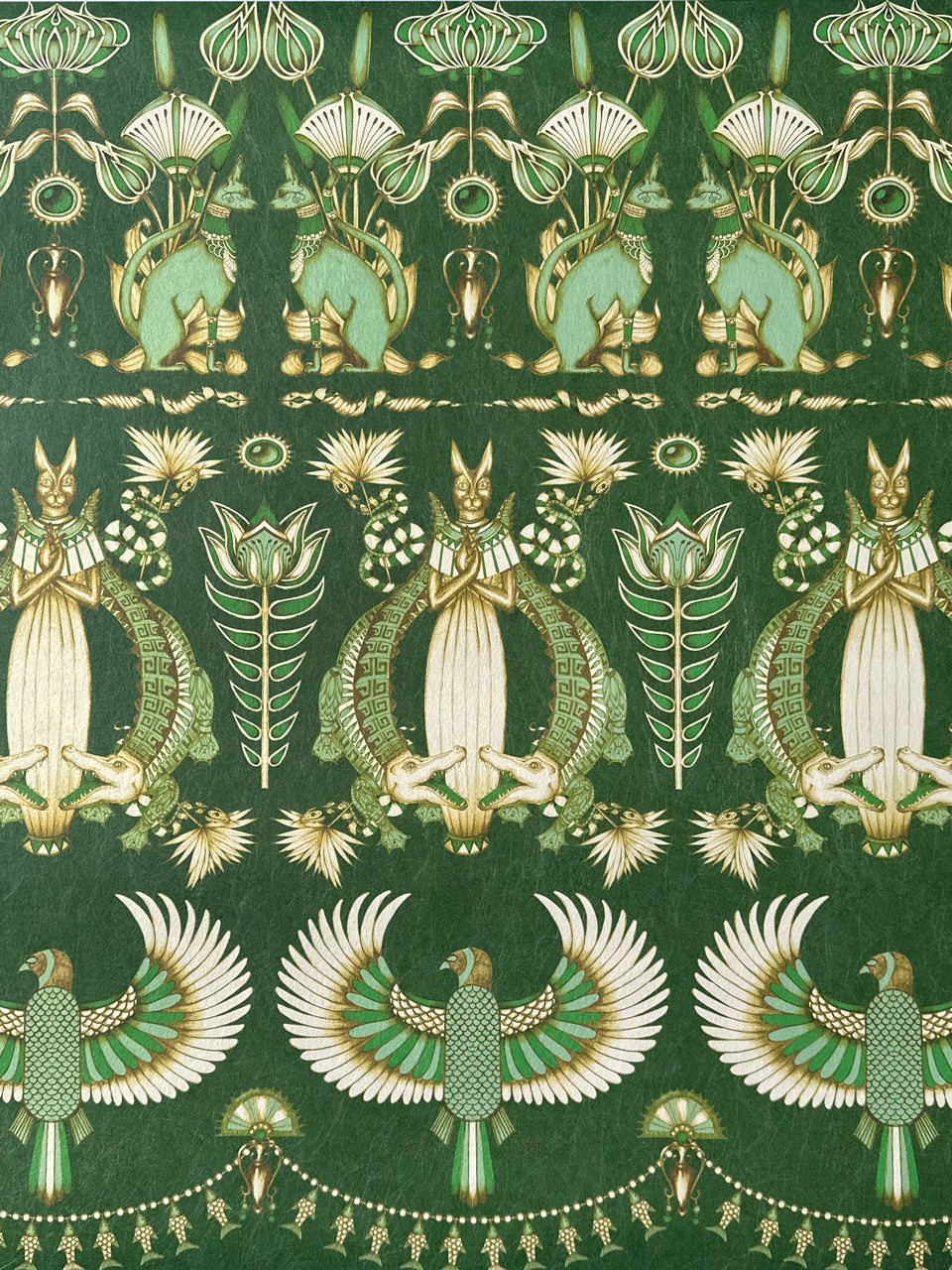 Close-up of Nefertiti Green wallpaper showing forest green motifs and golden parchment detail.