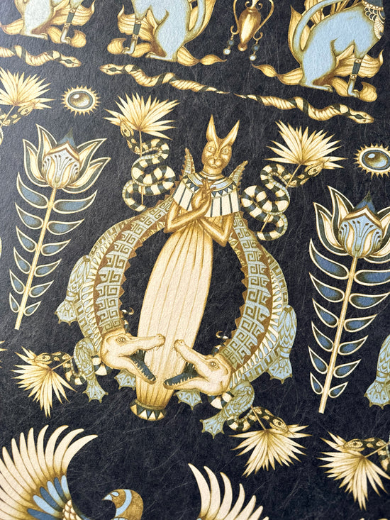 Detailed view of crocodile and sacred cat in Nefertiti Navy wallpaper on midnight blue and gold parchment.