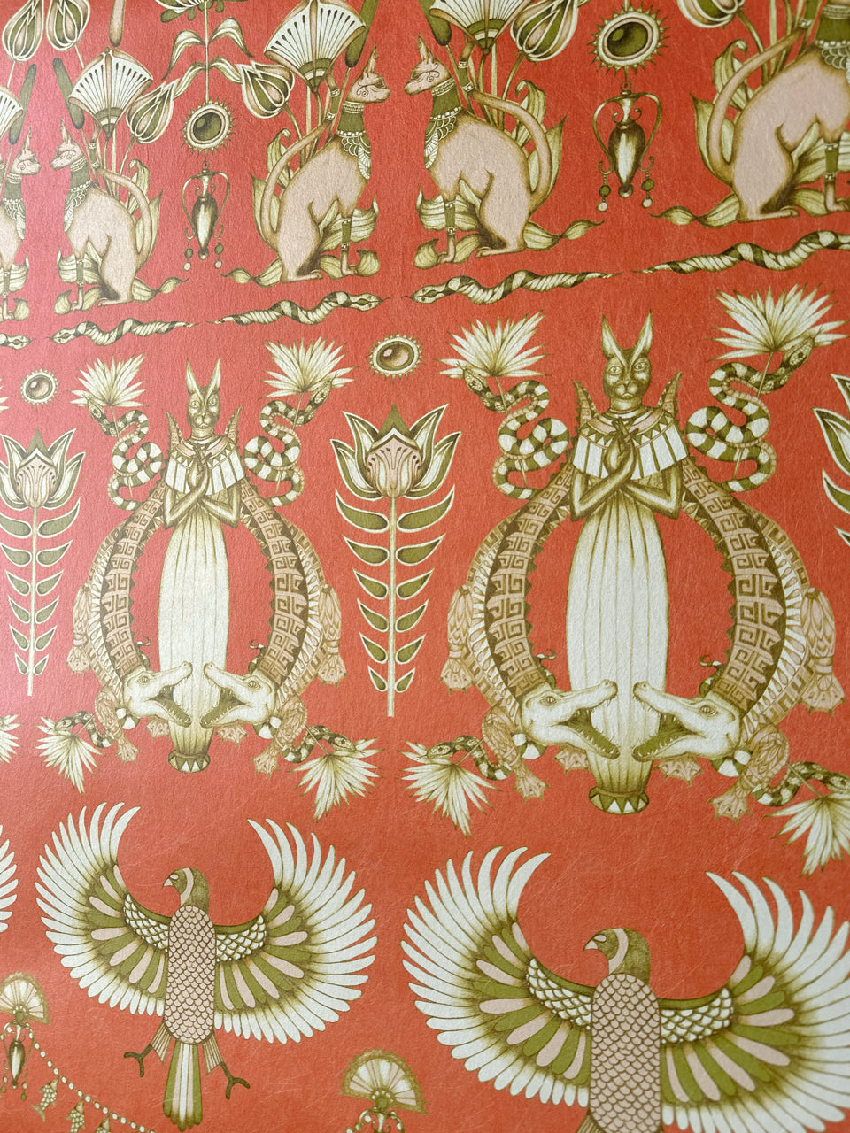 Close-up view of coiled snakes and Egyptian blooms in a maximalist, opulent gold finish.