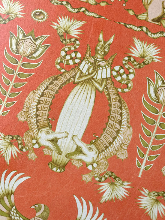 Crocodile and snake illustration in shimmering gold ink on Nefertiti’s burnt orange backdrop.