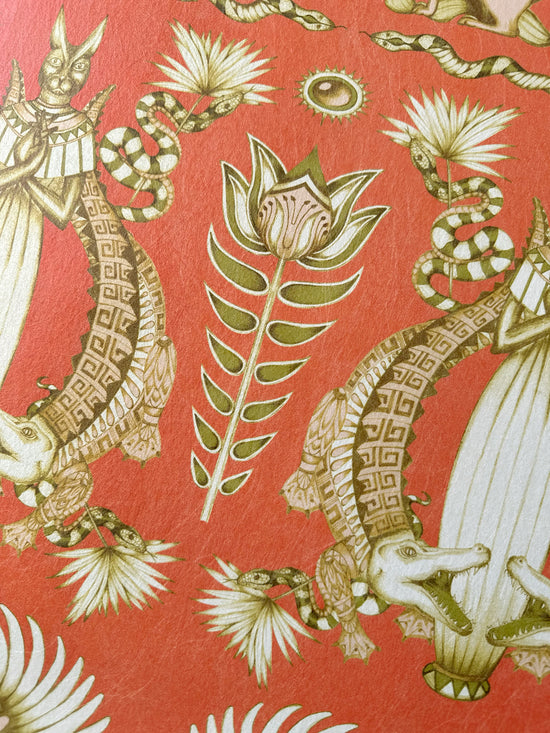 Detailed shot of peach-toned Egyptian floral motif with papyrus and lotus on Nefertiti Orange wallpaper.
