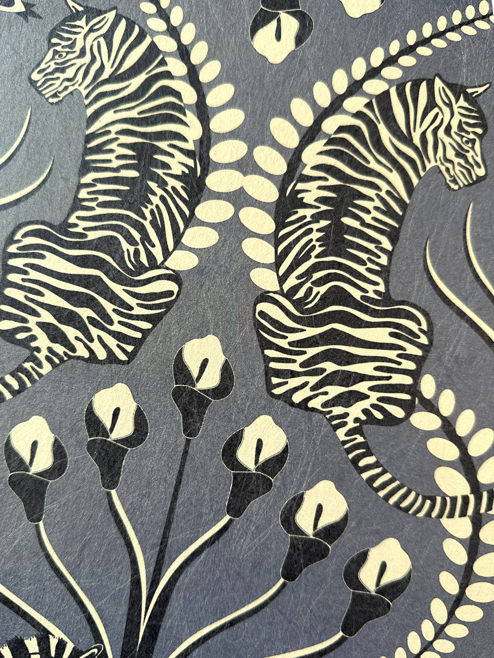 Tiger detail in dark pewter tones with floral print on Secret Garden Safari Black wallpaper.