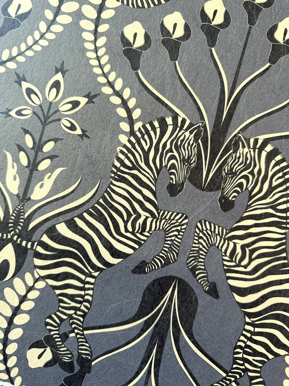 Close-up of Secret Garden Safari Black wallpaper with champagne gold folk florals and zebra.