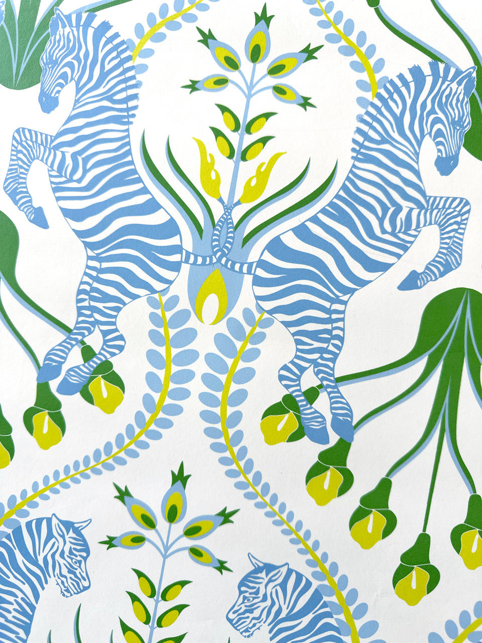 Close-up of zebra motif on powder blue wallpaper with folk details in a luxury cottage-style setting.