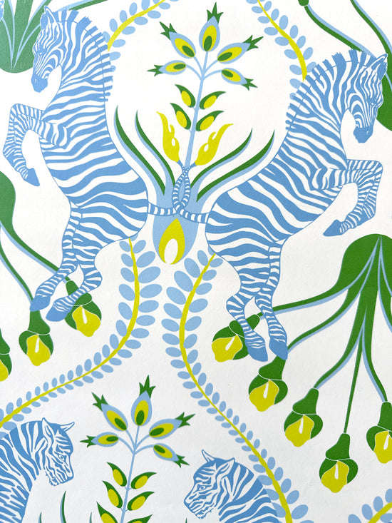 Close-up of zebra motif on powder blue wallpaper with folk details in a luxury cottage-style setting.