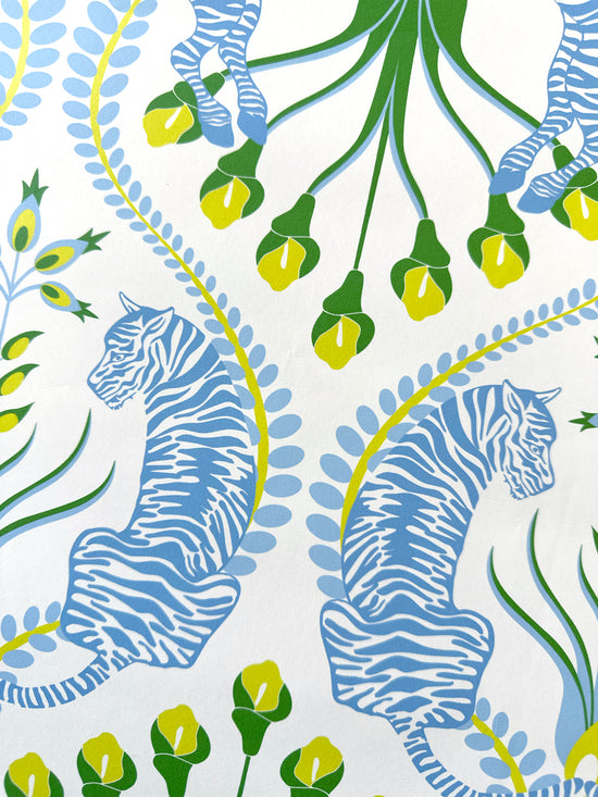 Close-up detail of tiger and floral accents on powder blue maximalist wallpaper with yellow botanical touches.