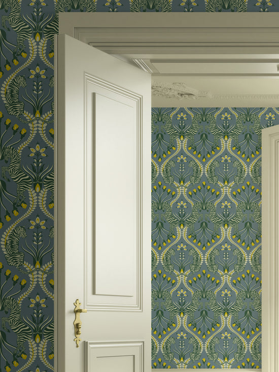 Grey bedroom featuring Secret Garden Safari wallpaper with botanical motifs and animal prints in ochre and eucalyptus.