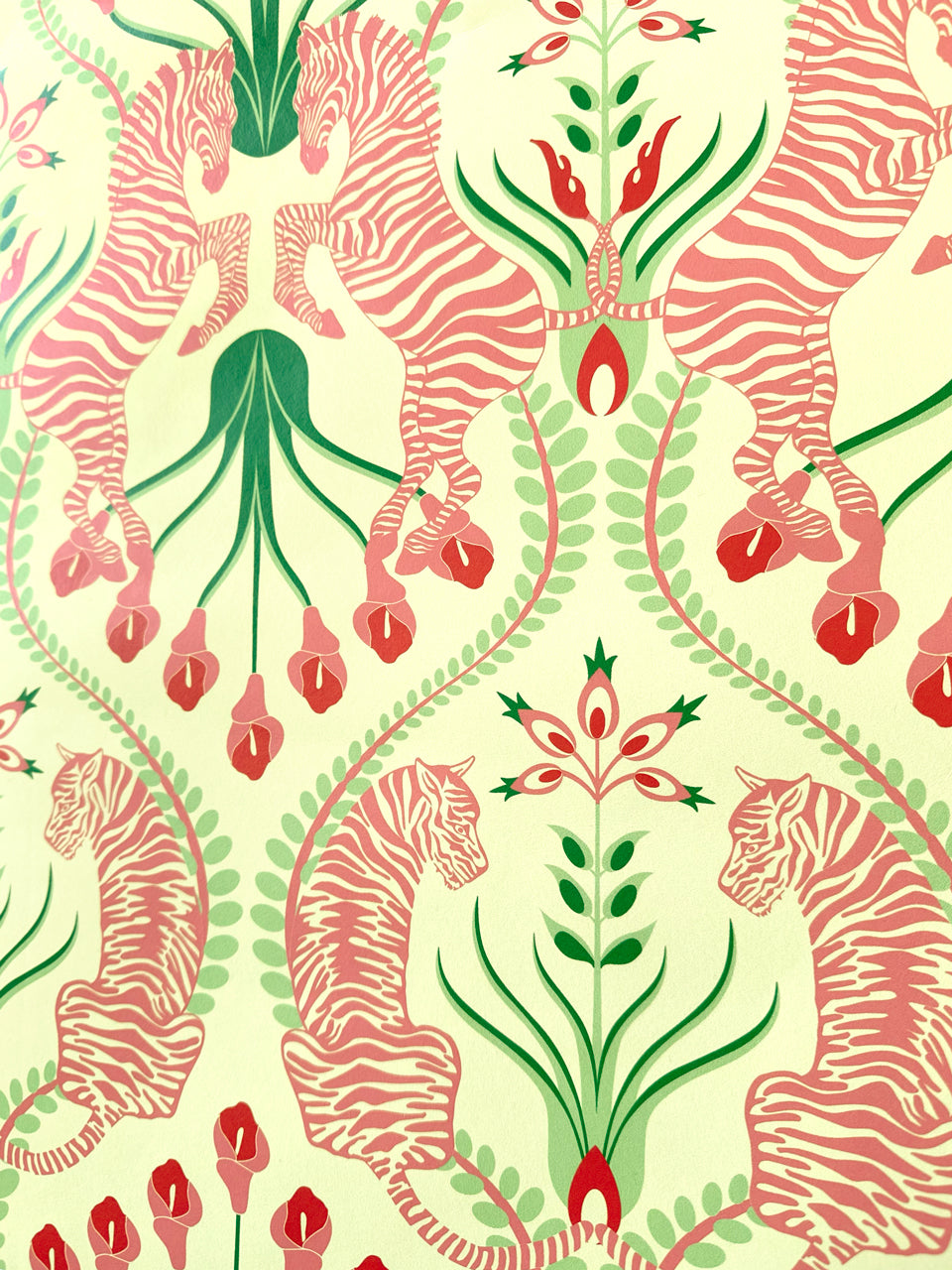 Feminine maximalist interior with Secret Garden Safari Pink wallpaper featuring symmetrical zebras and tigers in rosy tones on cream background.