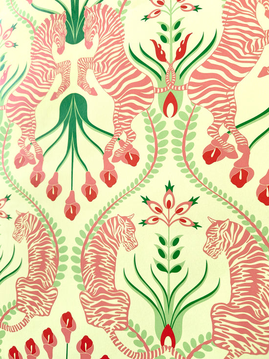 Feminine maximalist interior with Secret Garden Safari Pink wallpaper featuring symmetrical zebras and tigers in rosy tones on cream background.