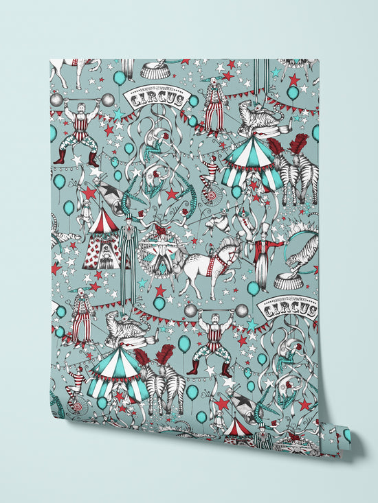Circus-themed wallpaper with performers, animals, and decorations on a light blue background.