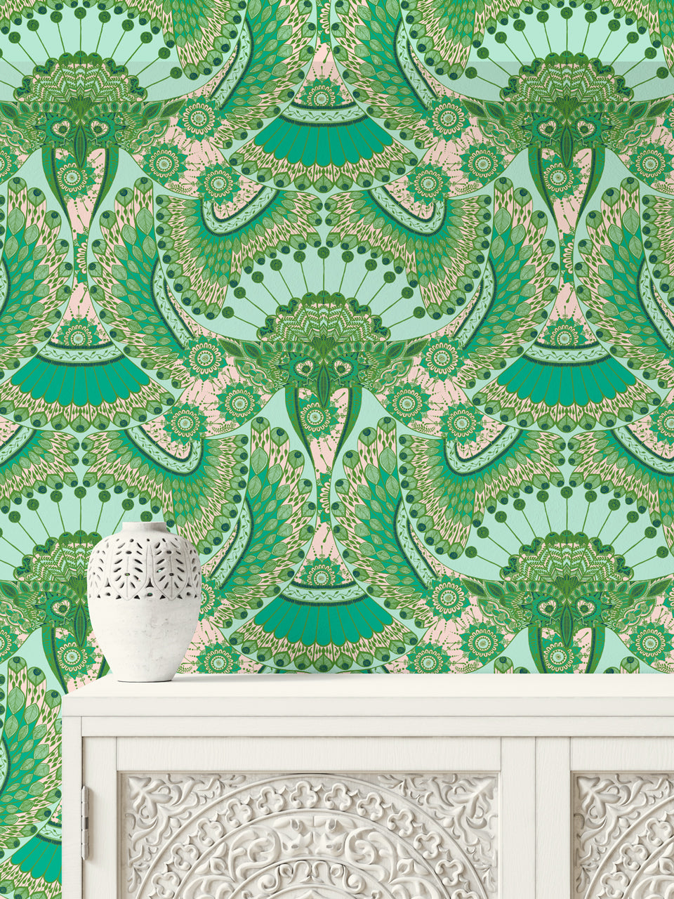 Ornate carved unit against blush pink Indian folk wallpaper with detailed parrot and botanical prints.