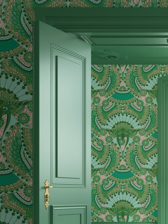 Bohemian style bedroom featuring grass green wallpaper inspired by Indian folk design and tropical birds.