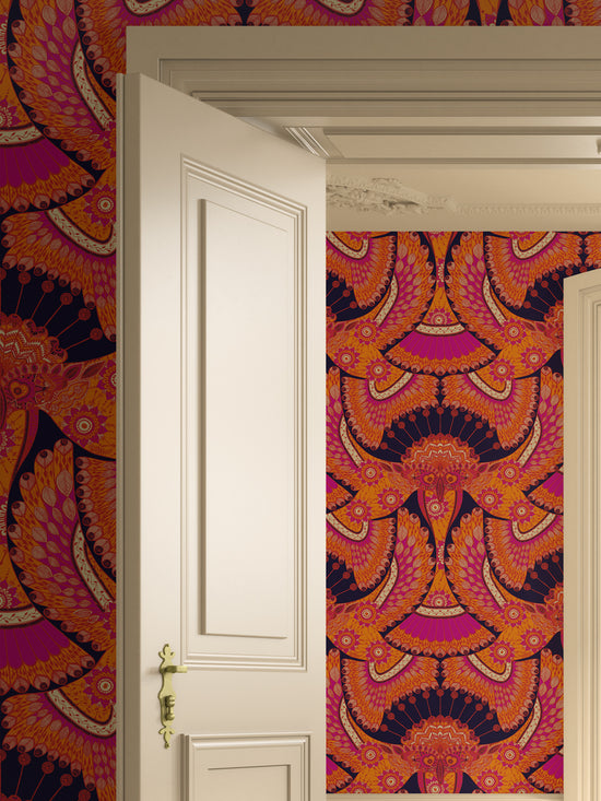 Vibrant Tota wallpaper in a doorway with bold orange and magenta detailing and a dramatic Boho-chic aesthetic.